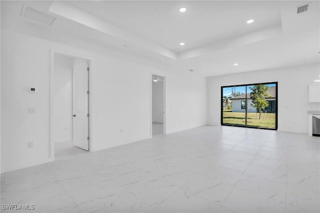 empty room featuring marble finish floor, a raised ceiling, visible vents, and recessed lighting