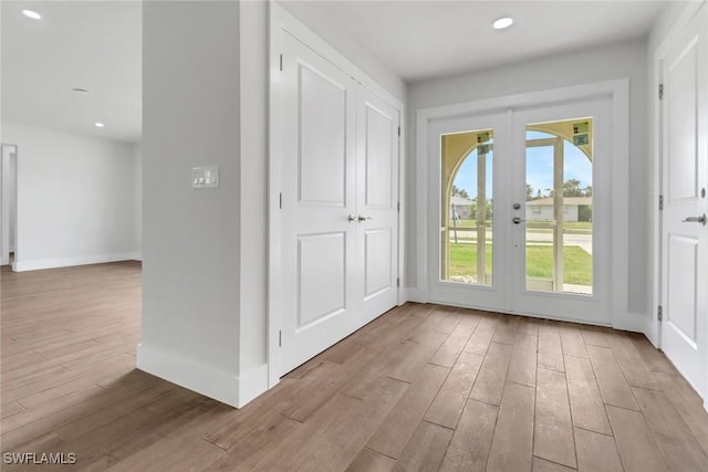 doorway to outside featuring light wood finished floors, baseboards, french doors, and recessed lighting