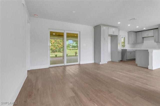 unfurnished living room featuring light wood-style floors, recessed lighting, and baseboards