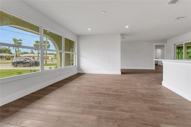 spare room featuring baseboards, wood finished floors, visible vents, and recessed lighting