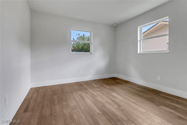 spare room featuring wood finished floors and baseboards