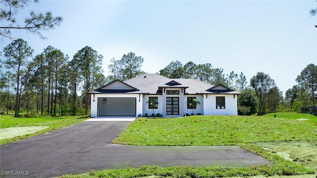 view of front of home featuring a front yard, a garage, and driveway