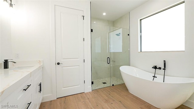 full bathroom featuring vanity, a soaking tub, wood finished floors, and a shower stall