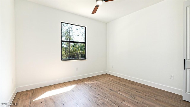 unfurnished room featuring a ceiling fan, wood finished floors, and baseboards