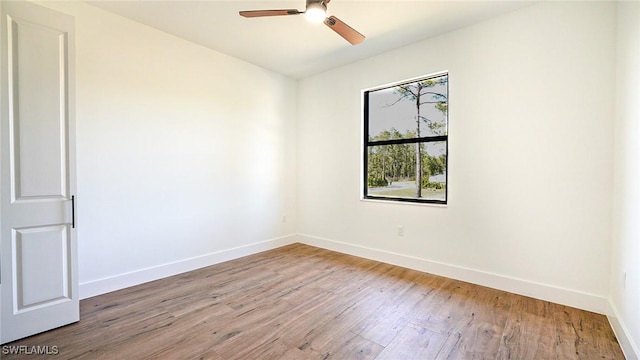 unfurnished room with a ceiling fan, wood finished floors, and baseboards