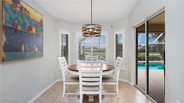 dining area with a chandelier, baseboards, and light tile patterned floors