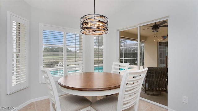 dining room with ceiling fan with notable chandelier, baseboards, and light tile patterned floors