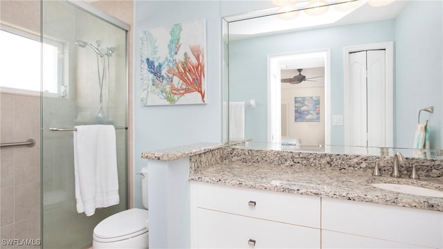 bathroom with a stall shower, vanity, and toilet