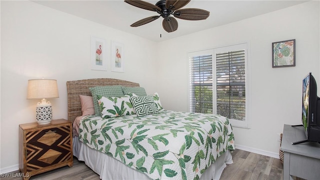 bedroom with a ceiling fan, baseboards, and wood finished floors