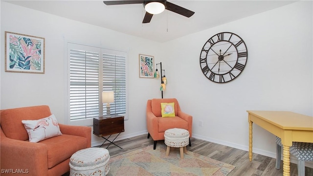 sitting room featuring a ceiling fan, baseboards, and wood finished floors