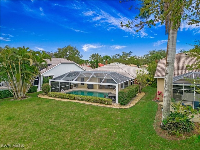 rear view of house featuring glass enclosure, an outdoor pool, a tiled roof, a yard, and stucco siding