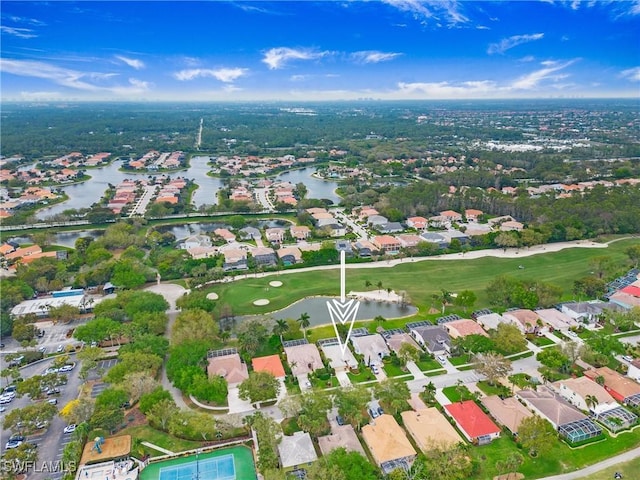 drone / aerial view featuring a residential view, view of golf course, and a water view