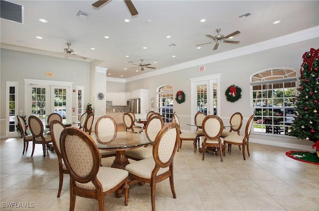 dining room with a wealth of natural light, visible vents, crown molding, and french doors