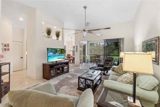 living area with a towering ceiling, recessed lighting, light tile patterned floors, baseboards, and ceiling fan