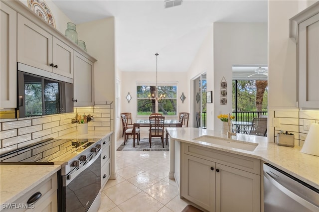 kitchen featuring light stone counters, range with electric stovetop, stainless steel dishwasher, and a peninsula