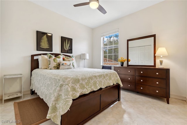 bedroom with light tile patterned floors, a ceiling fan, and baseboards