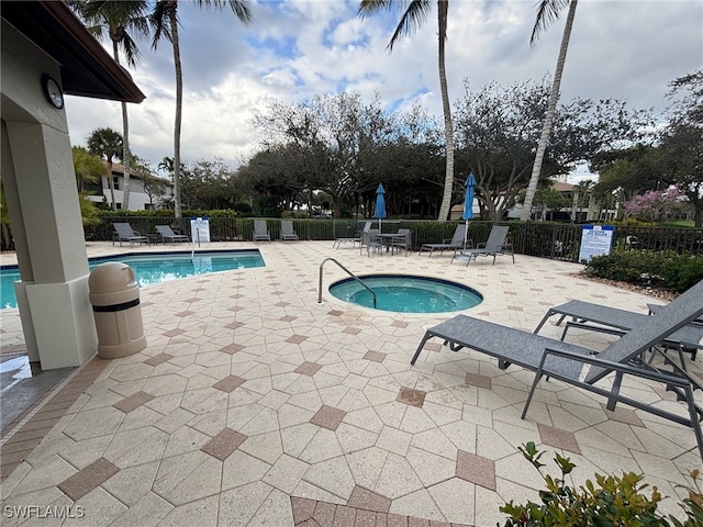 pool with a patio area and fence