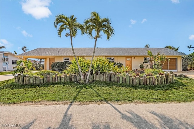 ranch-style home with driveway, a fenced front yard, and stucco siding