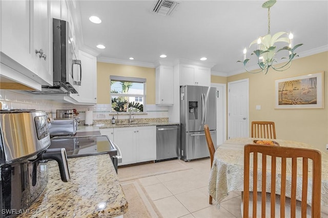 kitchen with a sink, crown molding, visible vents, appliances with stainless steel finishes, and a chandelier
