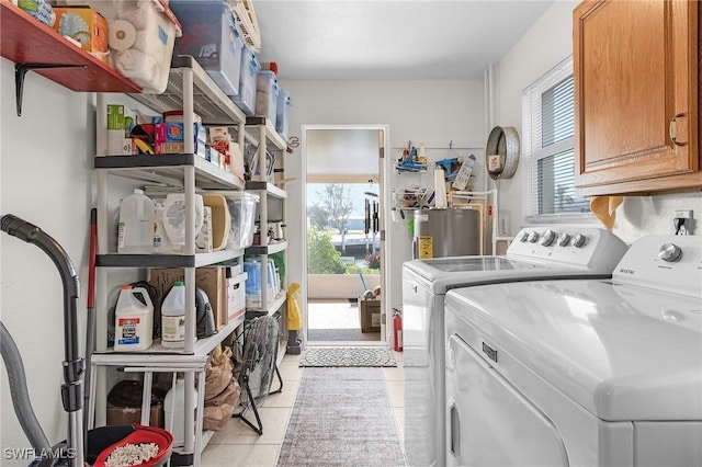 laundry room featuring light tile patterned flooring, cabinet space, water heater, and washing machine and clothes dryer