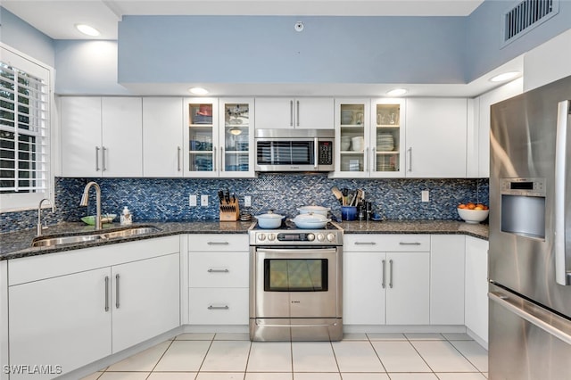 kitchen featuring appliances with stainless steel finishes, a sink, visible vents, and tasteful backsplash