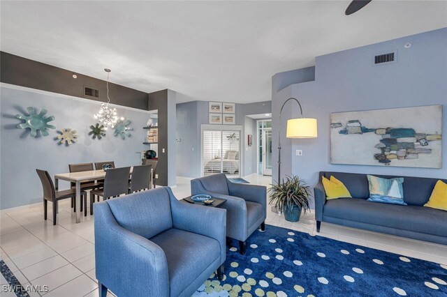 tiled living area featuring visible vents and a notable chandelier