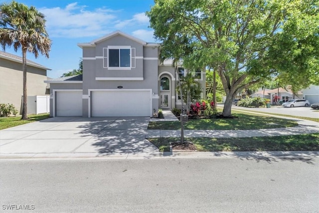 345 Sweet Bay Ln, Naples, FL 34119 - view of front of property featuring stucco siding, driveway, and an attached garage