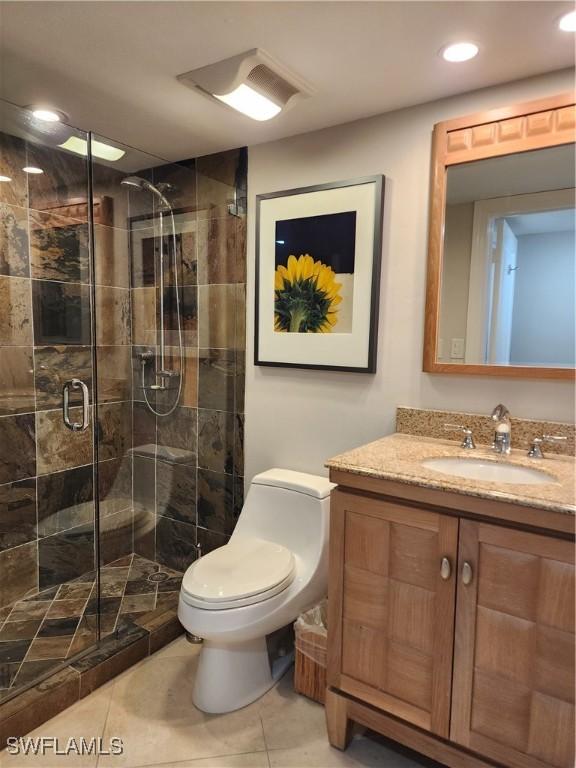 bathroom featuring toilet, tile patterned floors, vanity, a shower stall, and recessed lighting