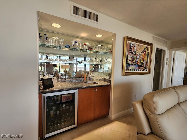 bar featuring beverage cooler, indoor wet bar, a sink, and visible vents