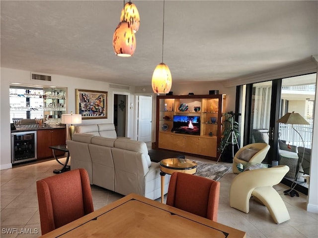 living area with wine cooler, visible vents, a bar, and light tile patterned floors