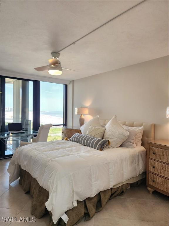 bedroom featuring light tile patterned floors, floor to ceiling windows, and a ceiling fan