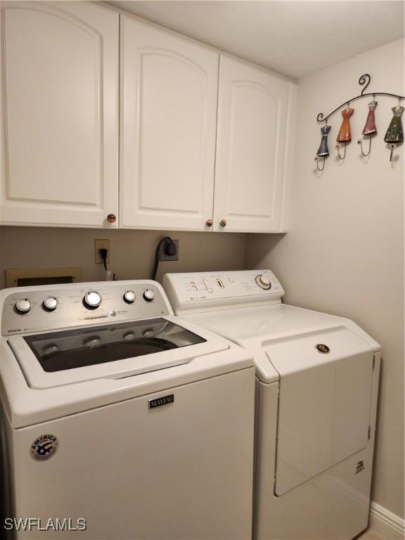 clothes washing area with cabinet space and washing machine and clothes dryer