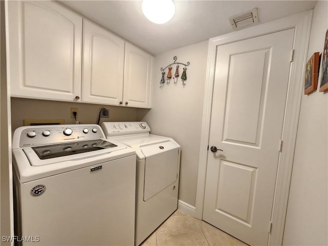 laundry room with light tile patterned floors, visible vents, baseboards, cabinet space, and washer and clothes dryer