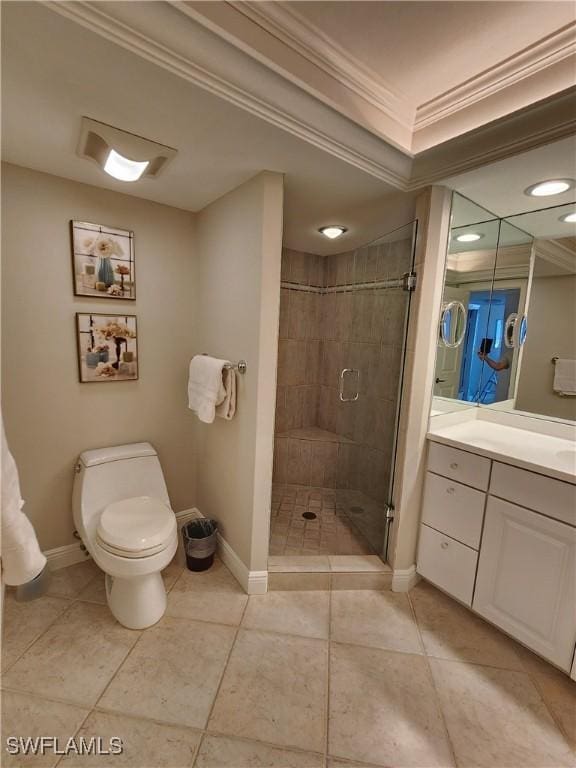 bathroom featuring baseboards, toilet, crown molding, vanity, and a shower stall