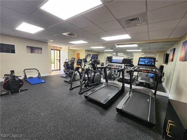 workout area with a paneled ceiling, visible vents, and baseboards