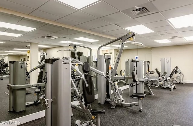 exercise room with a paneled ceiling and visible vents