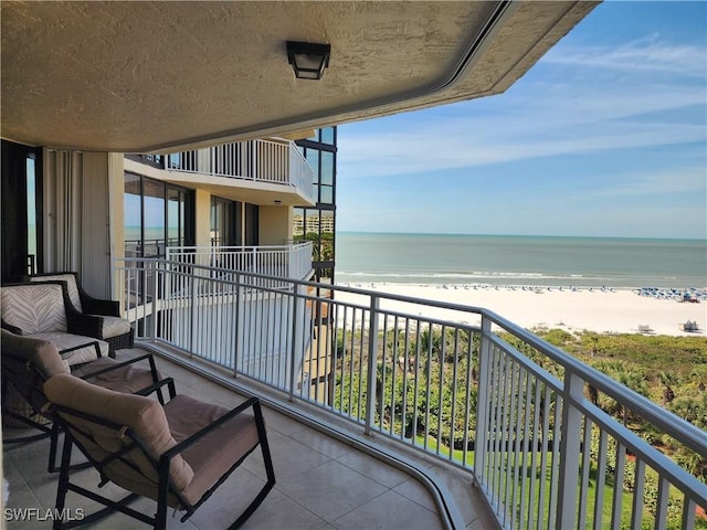 balcony featuring a water view and a view of the beach