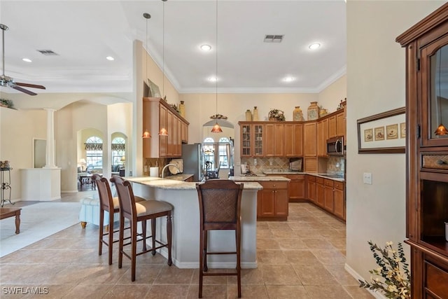 kitchen featuring decorative columns, visible vents, decorative backsplash, appliances with stainless steel finishes, and a peninsula