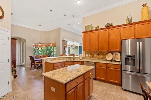 kitchen with tasteful backsplash, appliances with stainless steel finishes, brown cabinets, and a sink