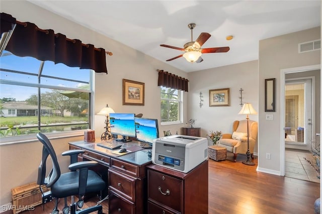 home office featuring a ceiling fan, visible vents, baseboards, and wood finished floors