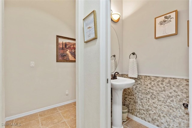 bathroom featuring tile patterned flooring, a sink, and baseboards