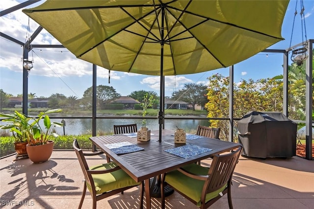 view of patio / terrace featuring outdoor dining area, a water view, and a lanai