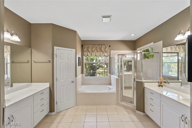 bathroom with a stall shower, two vanities, a garden tub, and tile patterned flooring