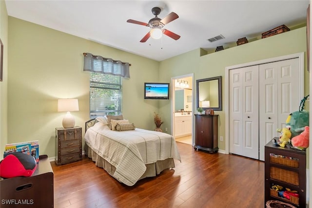 bedroom with hardwood / wood-style flooring, visible vents, a ceiling fan, baseboards, and a closet