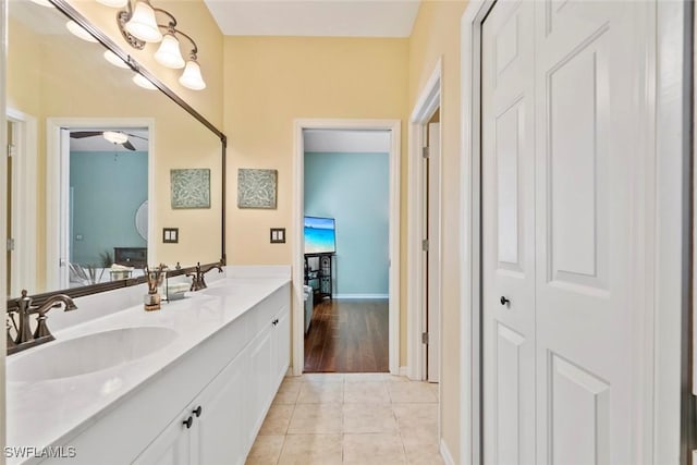 bathroom with a ceiling fan, tile patterned flooring, a sink, and double vanity