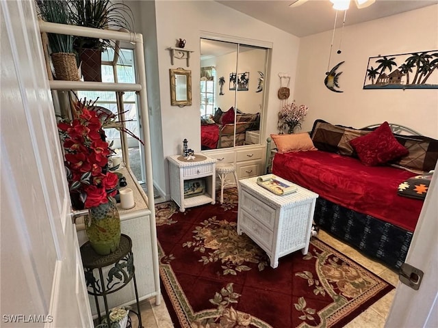 tiled bedroom with ceiling fan and vaulted ceiling