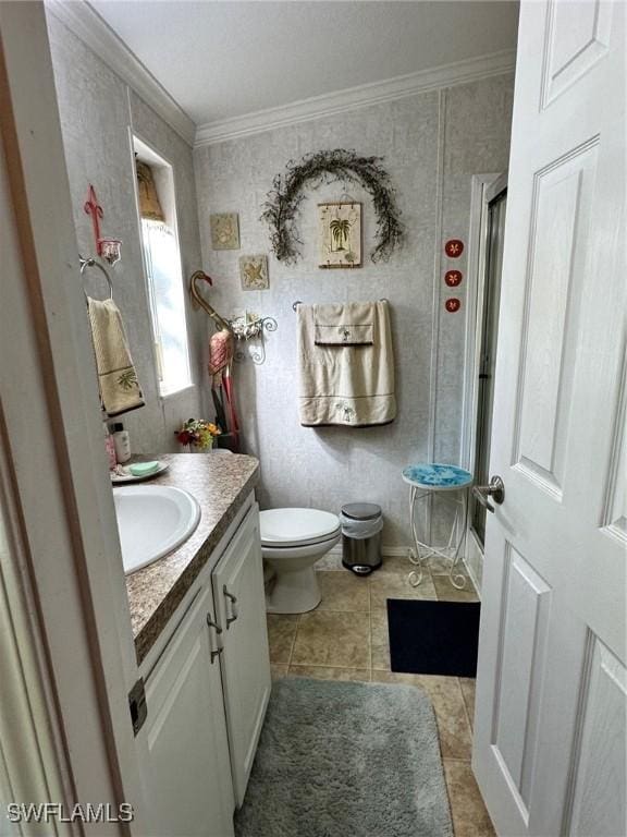 bathroom with tile patterned floors, a shower with shower door, vanity, and ornamental molding