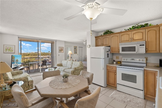 kitchen with white appliances, light tile patterned floors, a ceiling fan, light countertops, and open floor plan