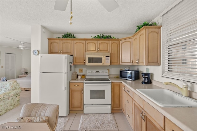 kitchen featuring a sink, white appliances, light countertops, light tile patterned floors, and ceiling fan