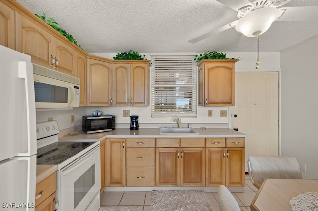 kitchen with light tile patterned floors, white appliances, light countertops, and a sink